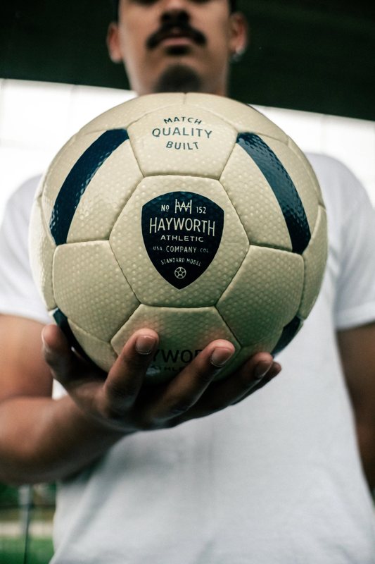A player holding the Standard Model No. 152 out to the camera, the crest facing forward.
